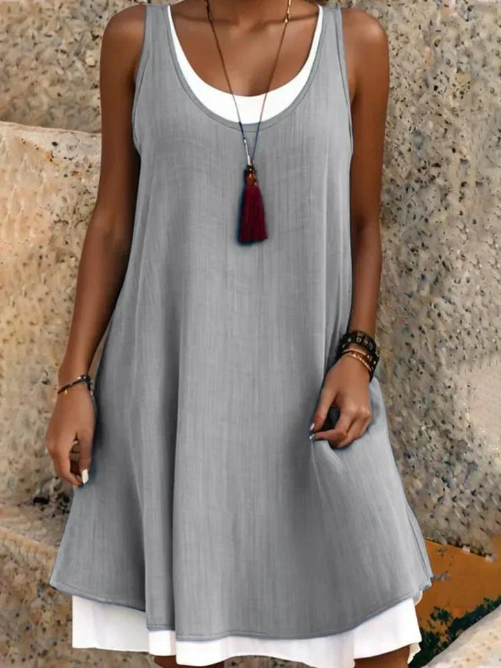 Stylish women's sleeveless mini dress, featuring a chic layered design and round neck for summer fashion.