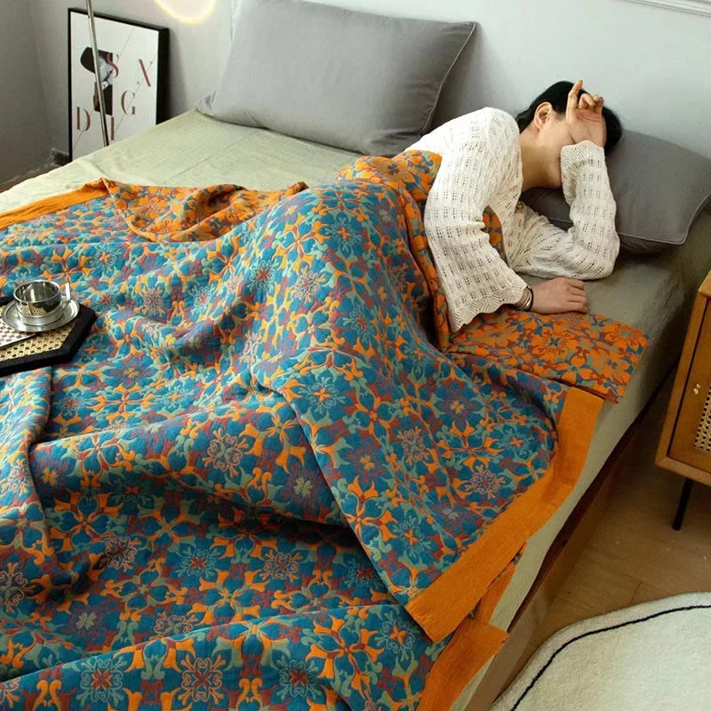 TerraLoom patterned cotton quilt in orange and blue, a six-layer design for cozy, eco-friendly home decor.