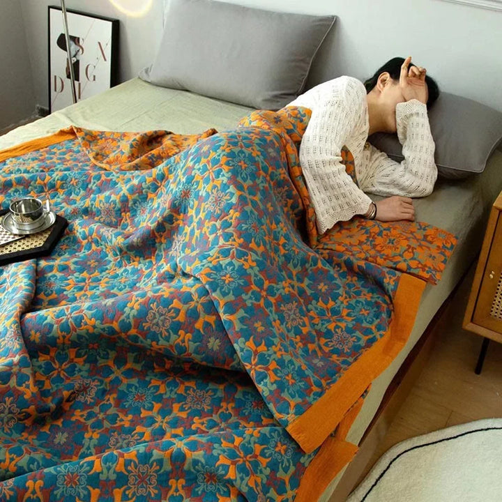 TerraLoom patterned cotton quilt in orange and blue, a six-layer design for cozy, eco-friendly home decor.