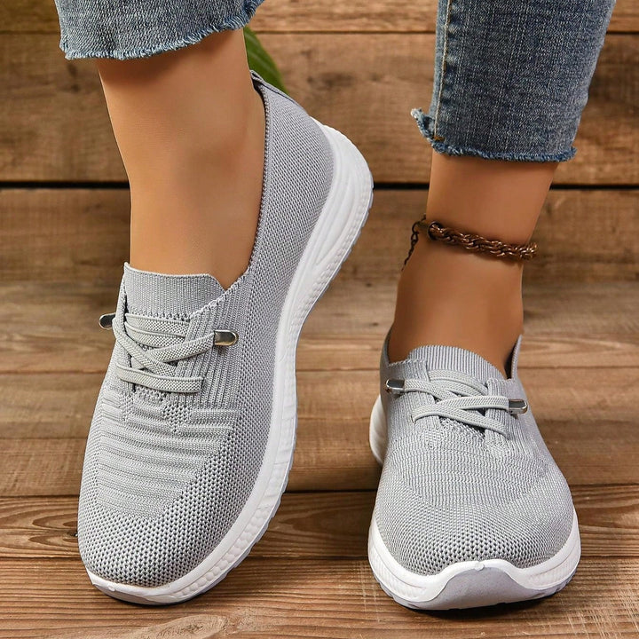 Stylish gray slip-on women's athletic sneakers, breathable with arch support & cushioned comfort.