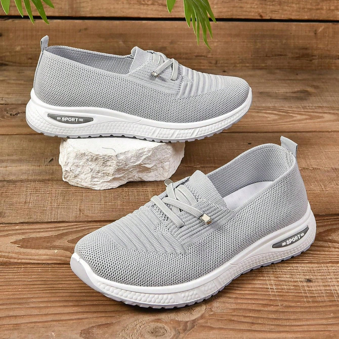 Gray women's orthopedic athletic shoes, designed for comfort, featuring arch support & cushioning for active days.