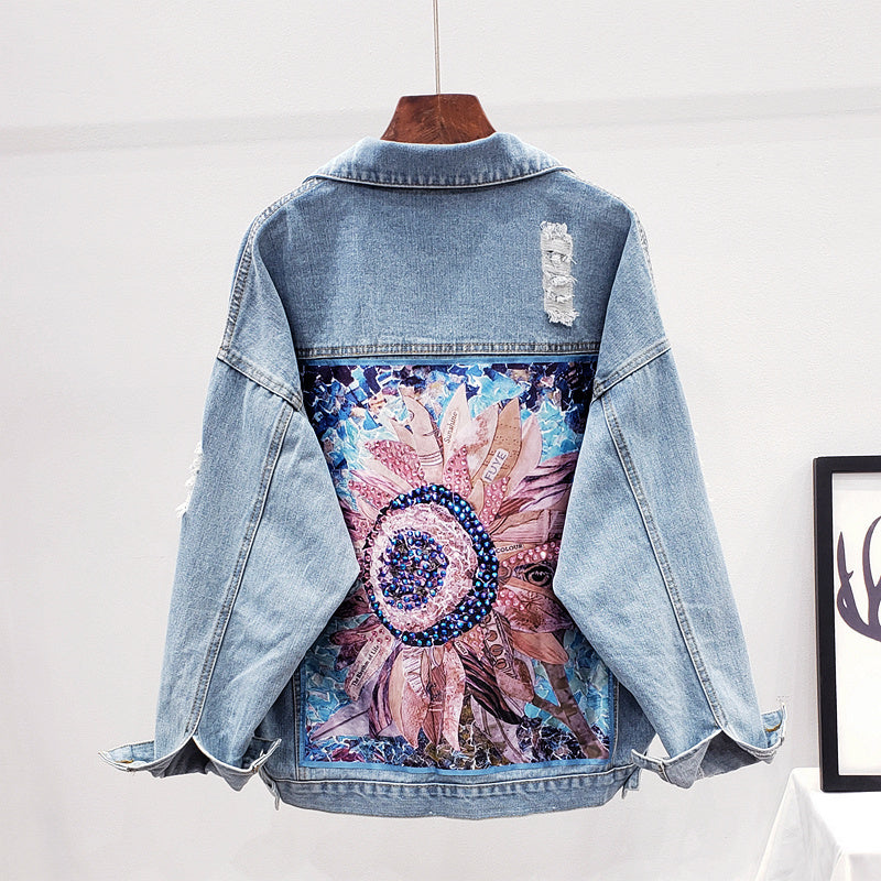 Women's oversized denim jacket, light wash, with a unique artistic print on the back. Perfect for street style.