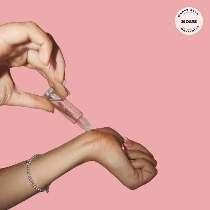 Person applying Pheromone Infused Unisex Perfume, a subtle fragrance designed to attract, boost confidence & natural scent.