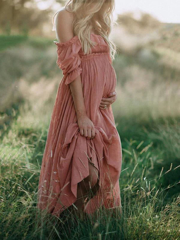 Comfortable flowy pinkish red off-shoulder maxi maternity dress, chic pregnancy fashion for women.