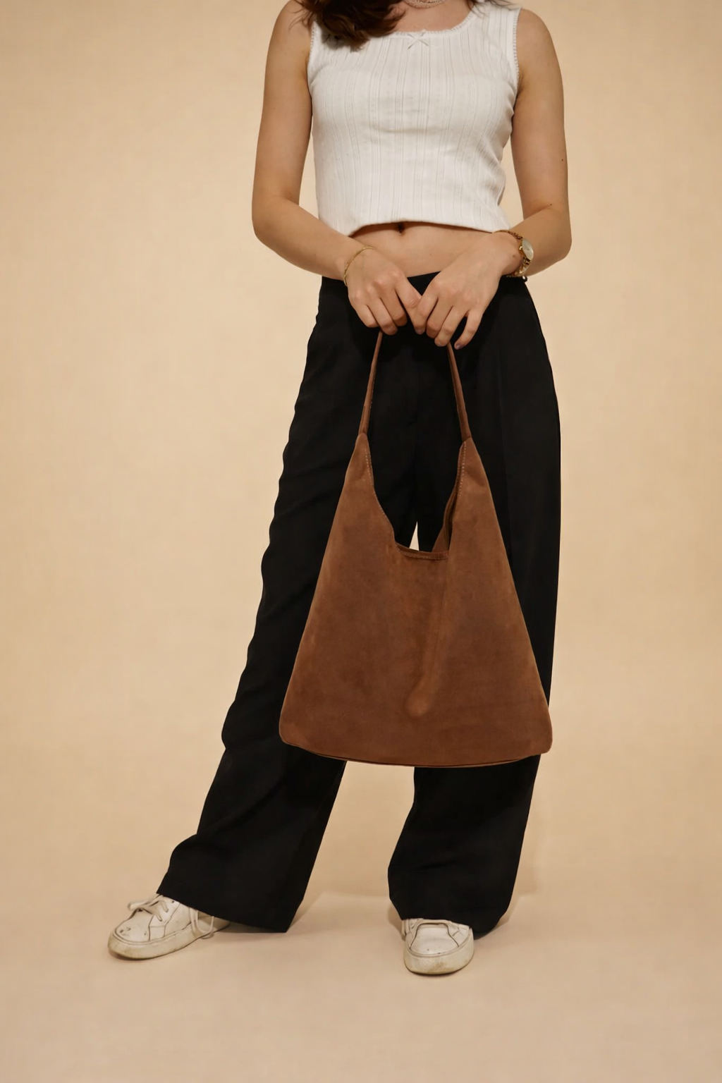 Close-up of a chic women's suede hobo bag. Showcases the minimalist design and soft texture of this shoulder handbag.