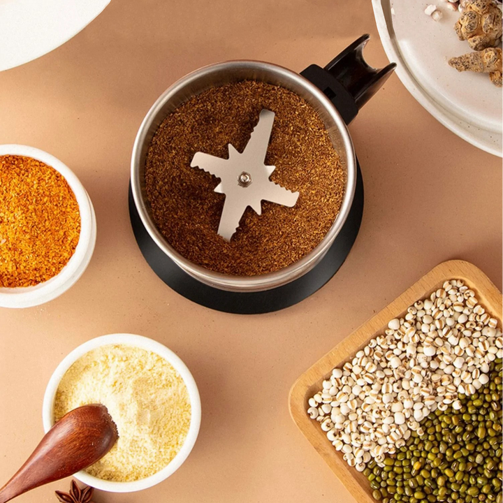 Electric herb & spice grinder processing dry ingredients. Compact, portable kitchen tool for quick use.