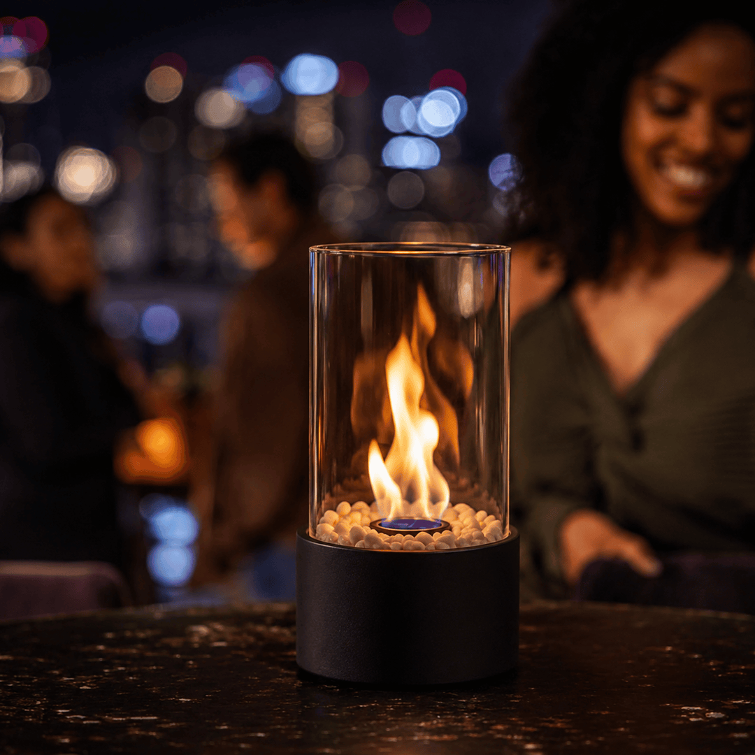White portable glass fireplace creating modern ambiance, smokeless ethanol tabletop burner for home.
