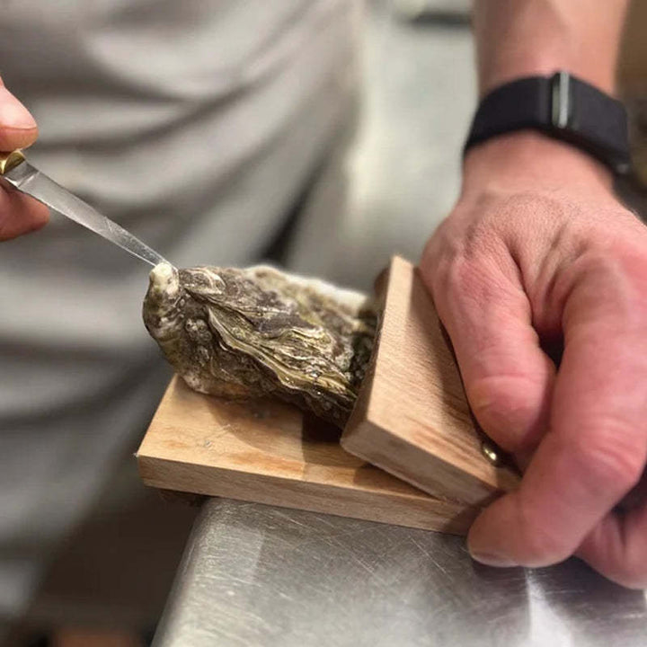 Elegant oyster shucking tool featuring a sturdy wood handle for comfortable grip, perfect for seafood lovers.