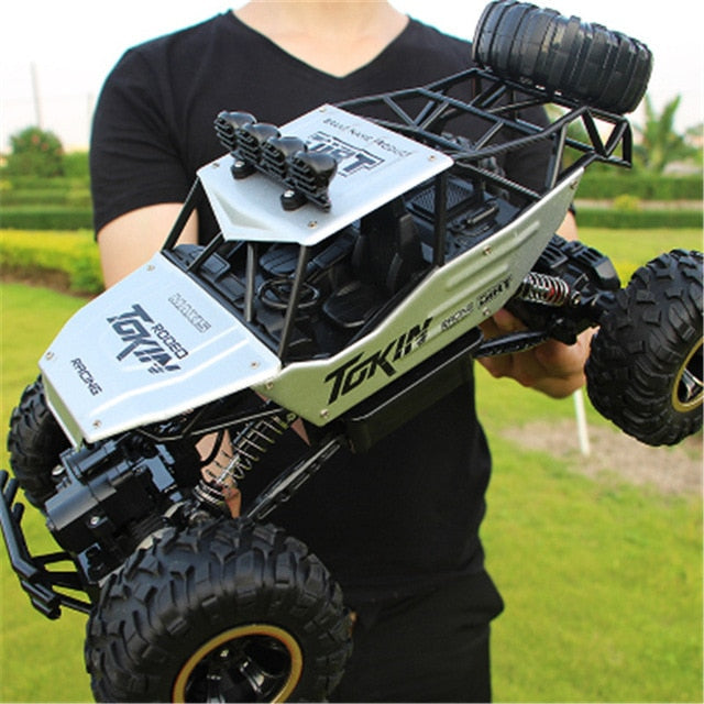 Kids' RC toy car driving over dirt & rocks. A rugged 4WD off-road adventure vehicle for play.