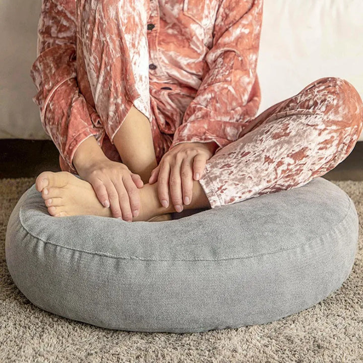 Plush polyester round cushion offering durable support for meditation and yoga poses.