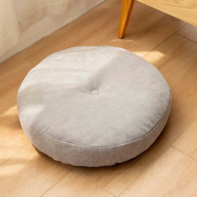 Comfortable polyester round floor pillow for stretching, meditation, and relaxation.