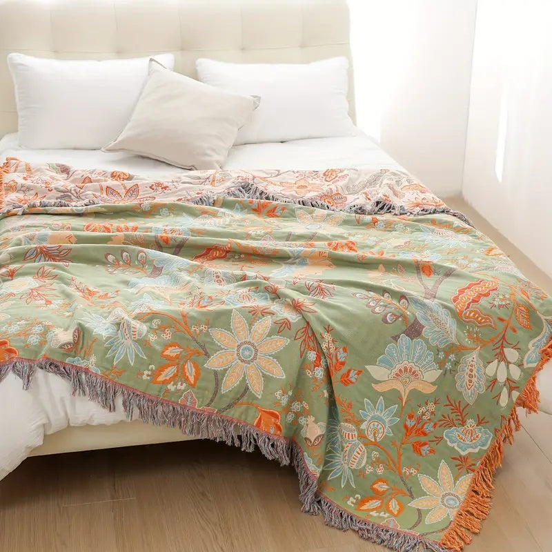 Bohemian style cotton throw blanket featuring a charming floral pattern. Adds cozy rustic flair to home decor.