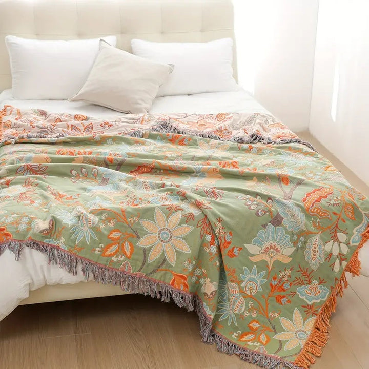 Bohemian style cotton throw blanket featuring a charming floral pattern. Adds cozy rustic flair to home decor.