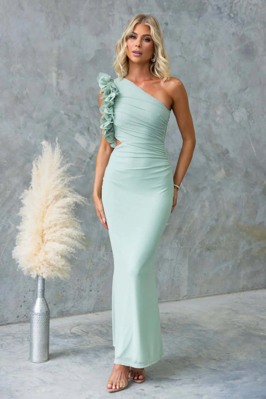 Details of the one-shoulder and ruffle on a luxurious women's long formal event dress, elegant.