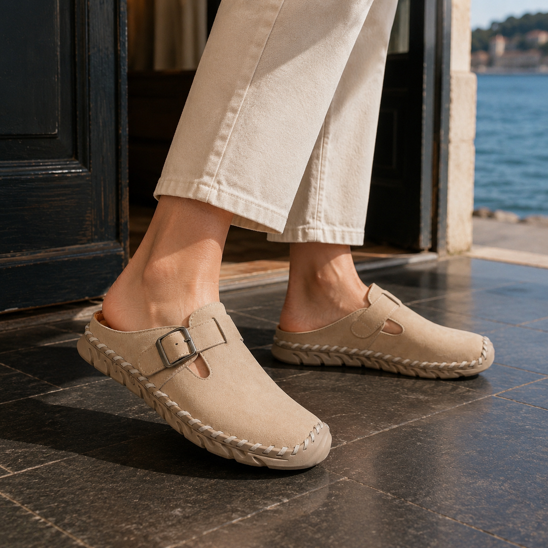 Men's elegant black slip-on clogs with adjustable buckle strap and stitched sole, perfect for casual style.