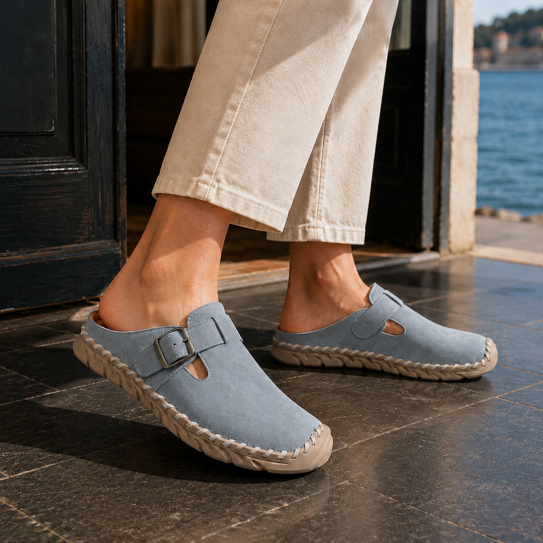 Stylish men's black mules, slip-on comfort, featuring a prominent buckle detail and durable stitched sole.