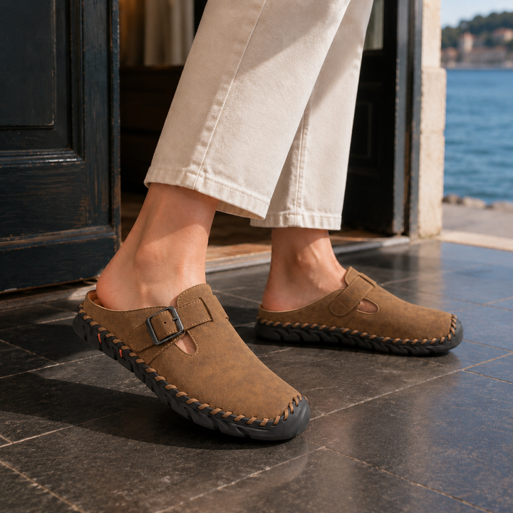 Elegant men's clogs, black, with a functional buckle strap and detailed stitched sole, ideal for everyday fashion.
