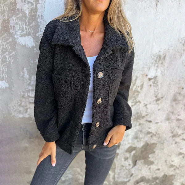 Women's stylish short teddy coat with lapel collar. Cozy, warm jacket for autumn and winter fashion.