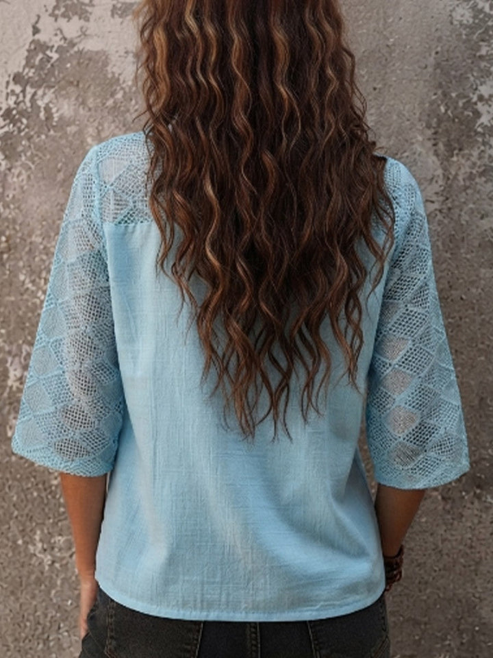 Elegant women's flowy tunic top with three-quarter sleeves & V-neck, featuring delicate crochet details.