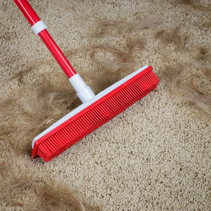Green silicone telescopic broom for pet hair removal on carpets, rugs, and hard floors. Adjustable home cleaning tool.