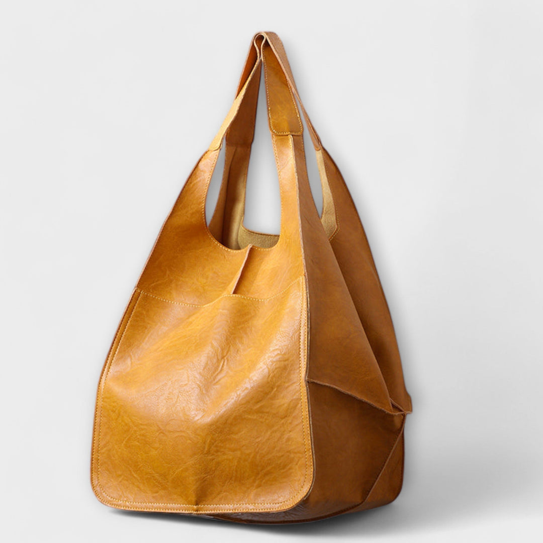 Stylish woman carrying black oversized leather travel tote, perfect for weekend getaways.
