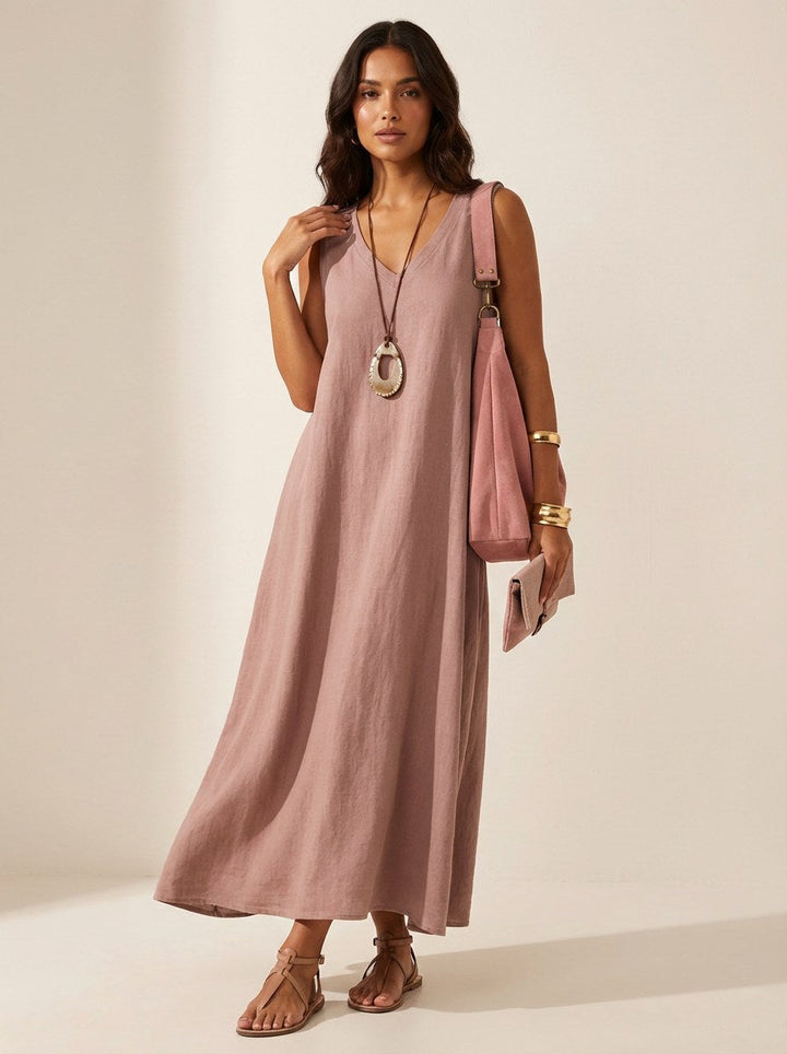 A woman walking in a graceful V-neck sleeveless flowing maxi dress, perfect for vacation or day wear.