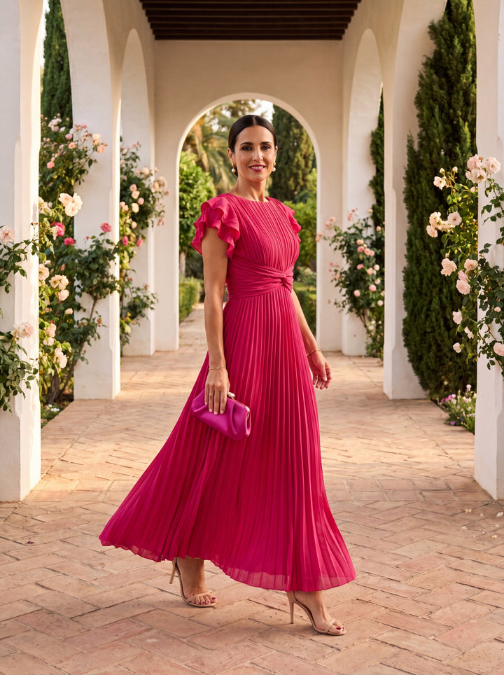 Close-up of a long women's pleated maxi dress, highlighting chic ruffles on the sleeves and flowy fabric.