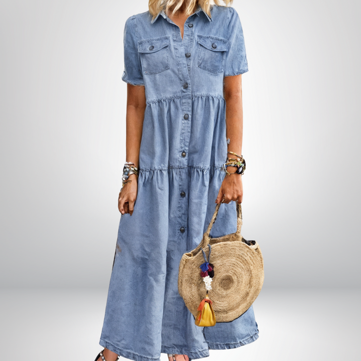Full length women's blue denim midi dress featuring button-front closure and stylish tiered skirt design.