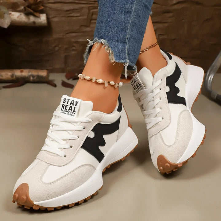 Close-up of modern women's striped platform sneakers, showcasing lace-up closure & a fashionable textured sole.