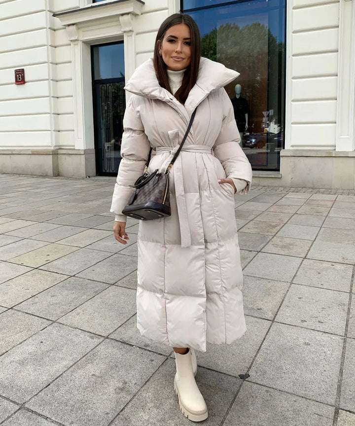 Elegant brown women's long puffer jacket, a stylish winter coat for cold weather and cozy fashion.