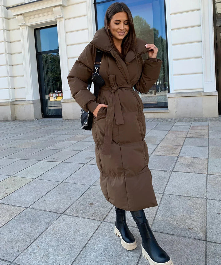 Black long puffer jacket for women, offering warm and cozy outerwear for harsh winter conditions.