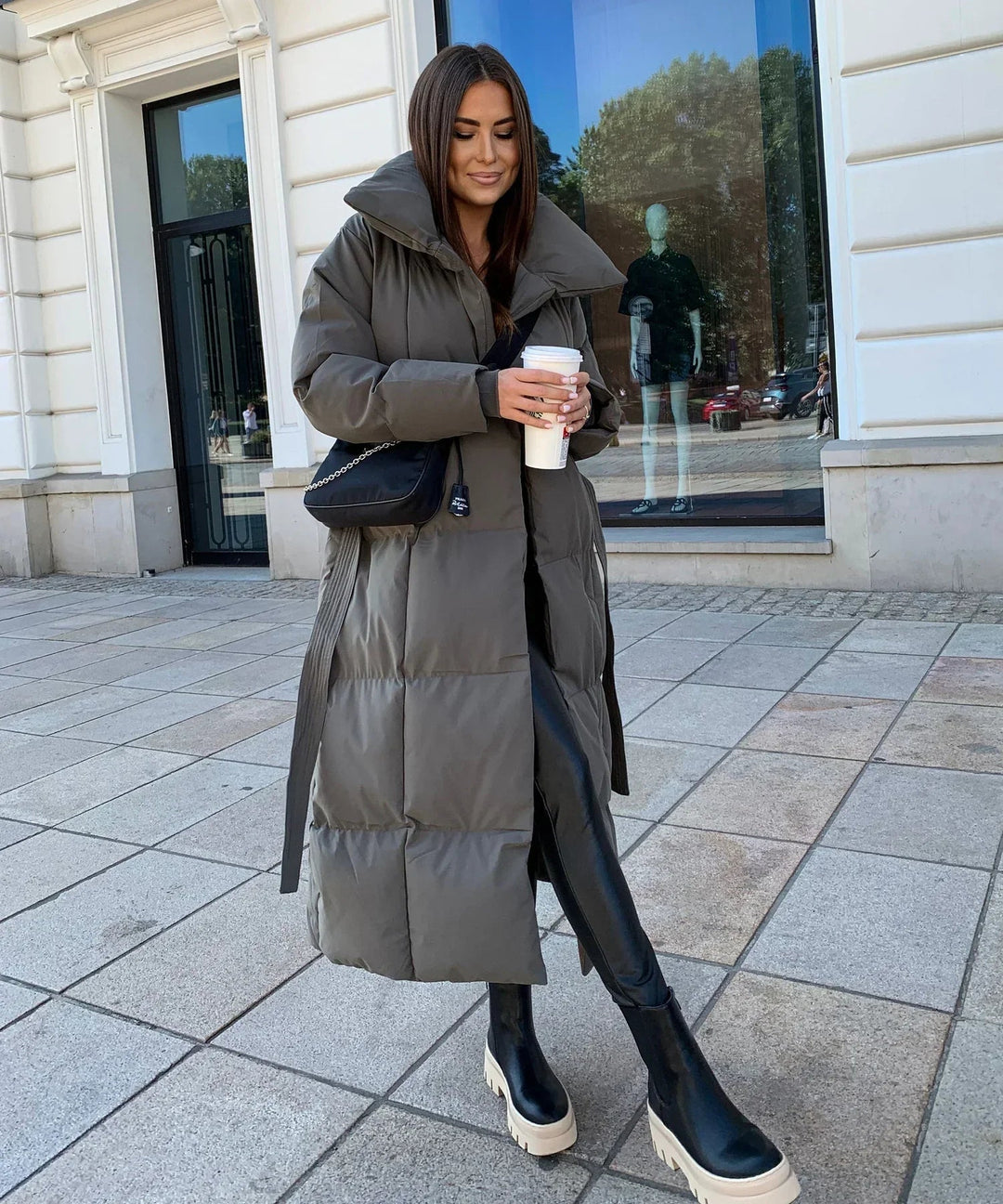 Comfortable brown long puffer jacket for women, providing cozy warmth and style in cold winter weather.