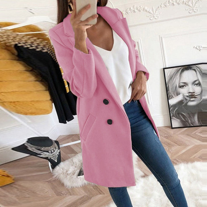 A woman walks in the city wearing the fashionable Mila long sleeve coat.