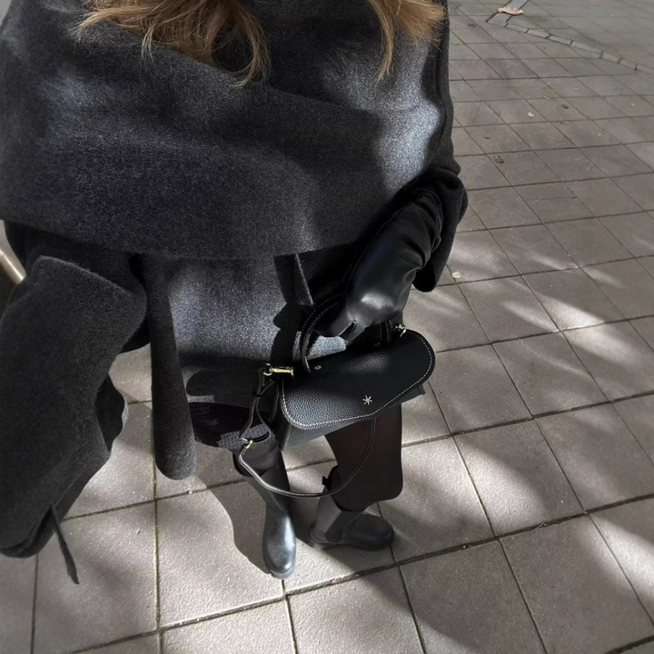 Oversized asymmetrical winter poncho for women, offering a comfortable and chic layered look.