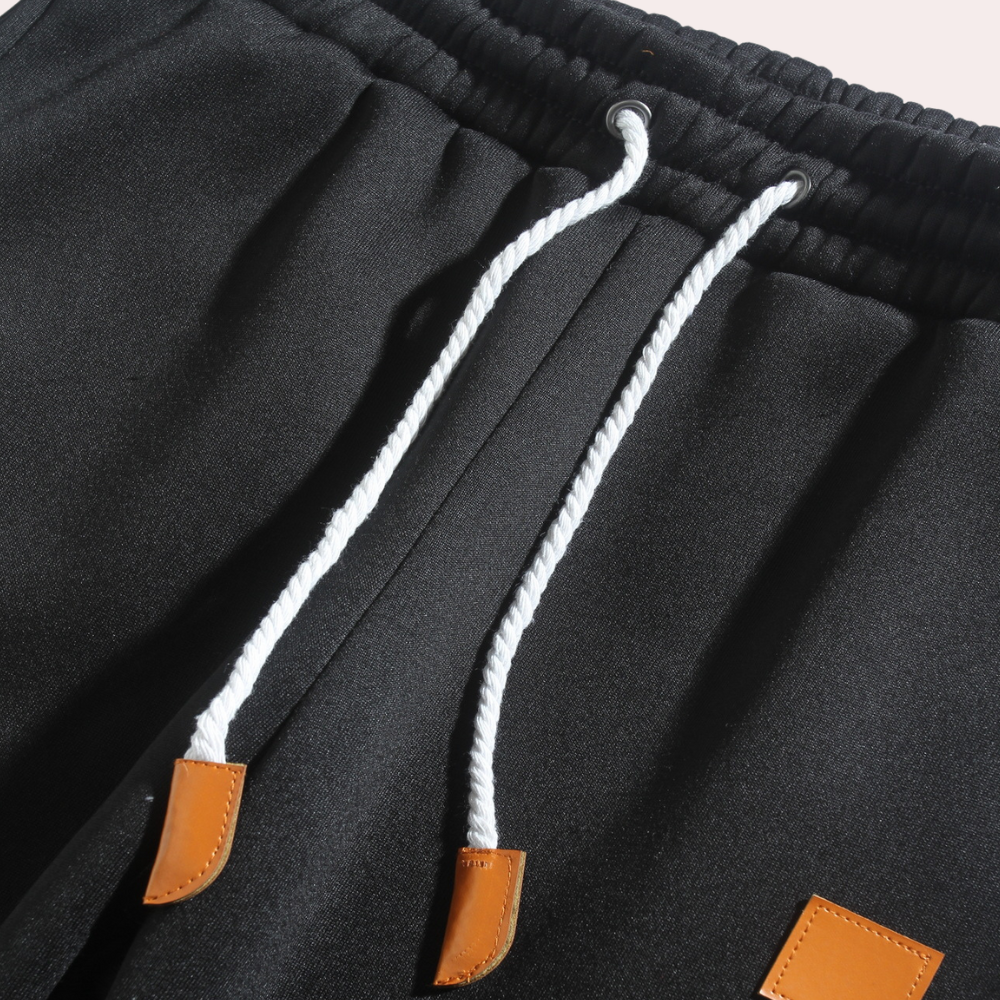 Close-up of men's baggy jogging pants showing comfortable elastic waist & tapered leg.