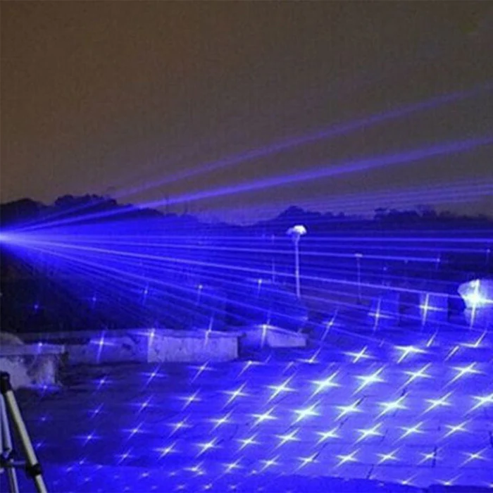 User holding a tactical laser torch in an outdoor camping setting for survival and navigation.