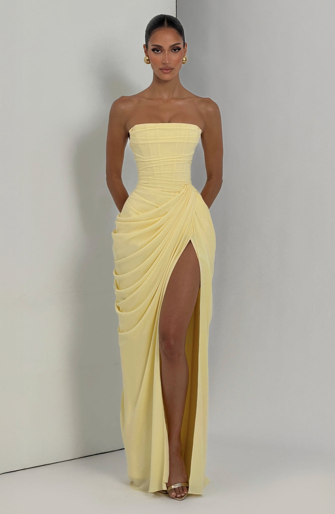 Back view of a women's strapless maxi evening dress, featuring intricate back lace detail and sculpted bodice.
