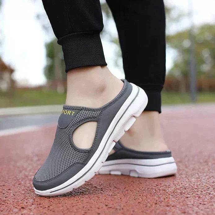 Grey men's comfort slip-on shoes with cushioned sole & arch support, providing foot relief.