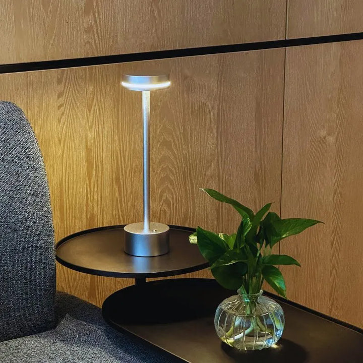 Modern aluminum table lamp with LED, dimmable and cordless, ideal for ambient light.