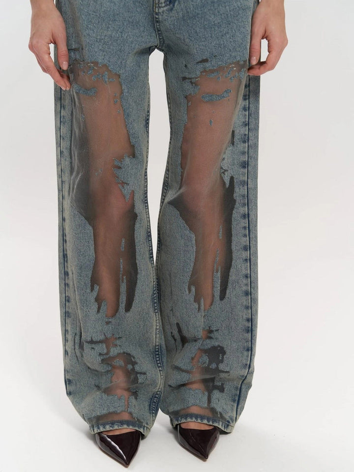 Trendy women's high waist blue jeans with a wide leg silhouette and stylish mesh panels, perfect for a chic look.
