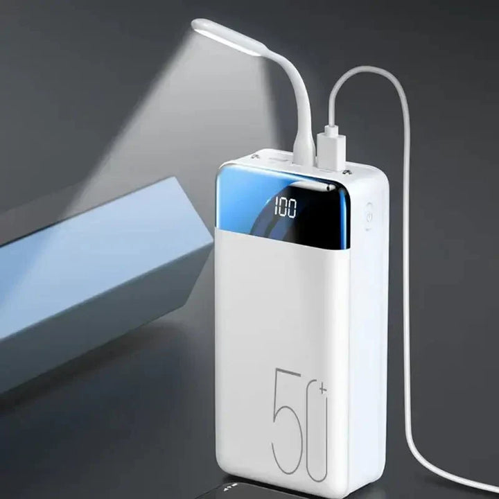 Compact 50000mAh high-capacity power bank next to a phone, perfect portable charger for fast mobile device charging.