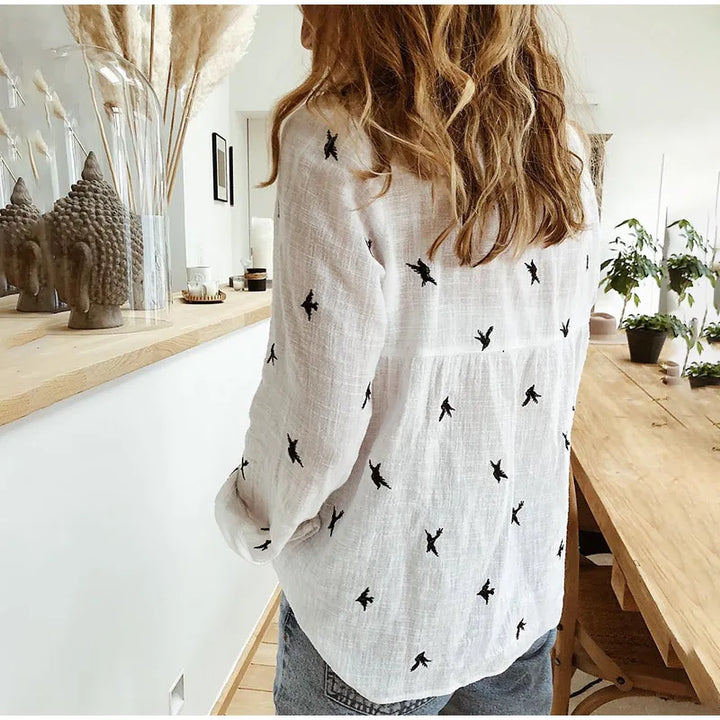 Casual women's button-up blouse featuring unique bird print and long sleeves. Summer style.