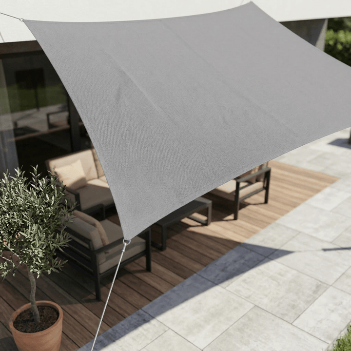 Grey waterproof sun sail providing shade over a garden patio.