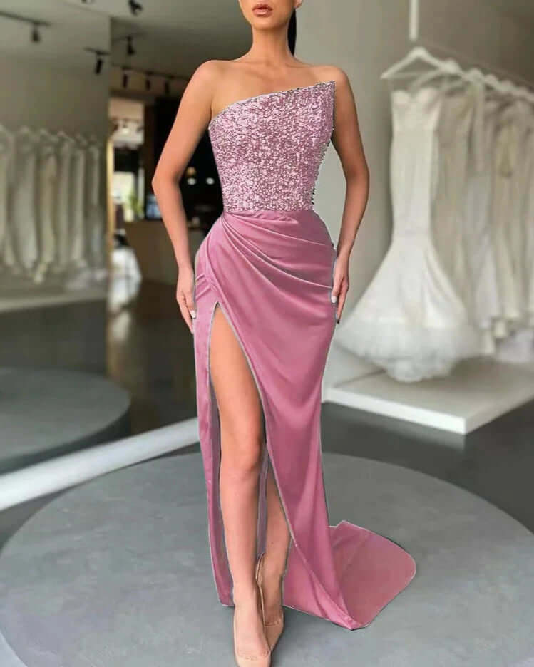 Long women's shimmering one-shoulder evening dress featuring a dramatic high slit, elegant for parties.