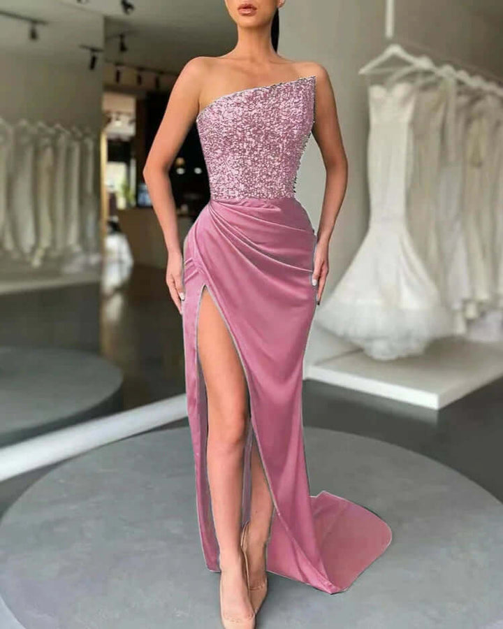 Long women's shimmering one-shoulder evening dress featuring a dramatic high slit, elegant for parties.