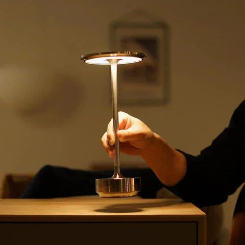 Modern wireless table lamp in a minimalist design, offering portable & dimmable light.