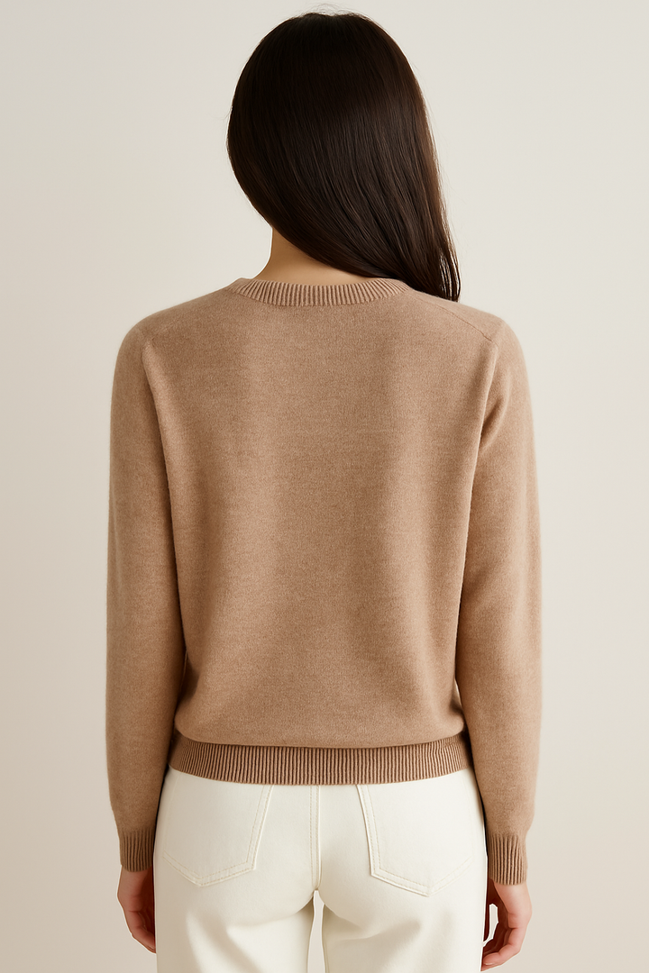 Close-up of a soft, cream-colored women's knit cardigan featuring a timeless button-front design.