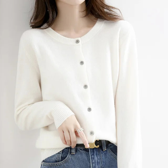 Detail shot of the ribbed texture on a women's soft knit cardigan with pearl-like front buttons.
