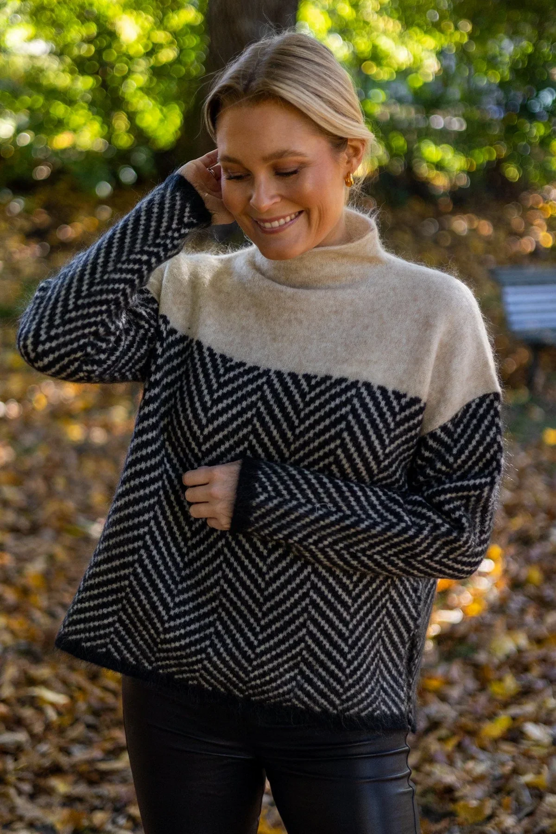 Close-up of a chic women's chevron knit turtleneck sweater, showcasing its warm texture.