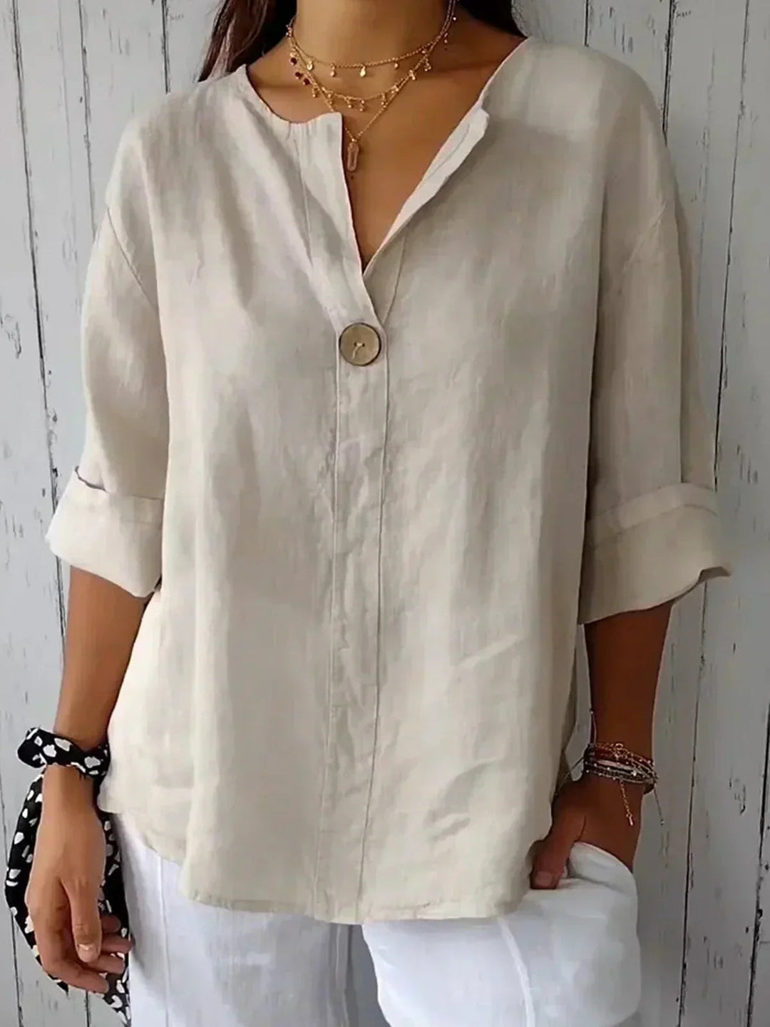 Women's effortlessly chic button-down blouse with a V-neck and 3/4 sleeves, perfect for casual chic wear.